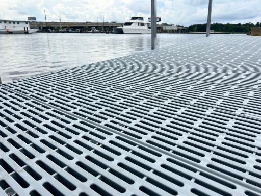 Textured metallic surface of a dock reflecting water and cloudy sky.